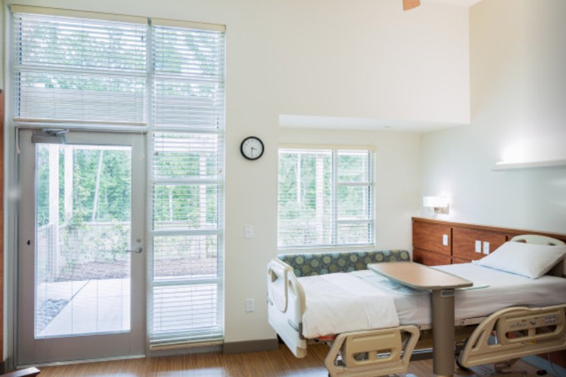 NC Hospice House patient room with window, comfortable seating and bed