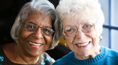 two senior women smiling at the camera