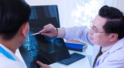 provider points at scan as he talks to patient